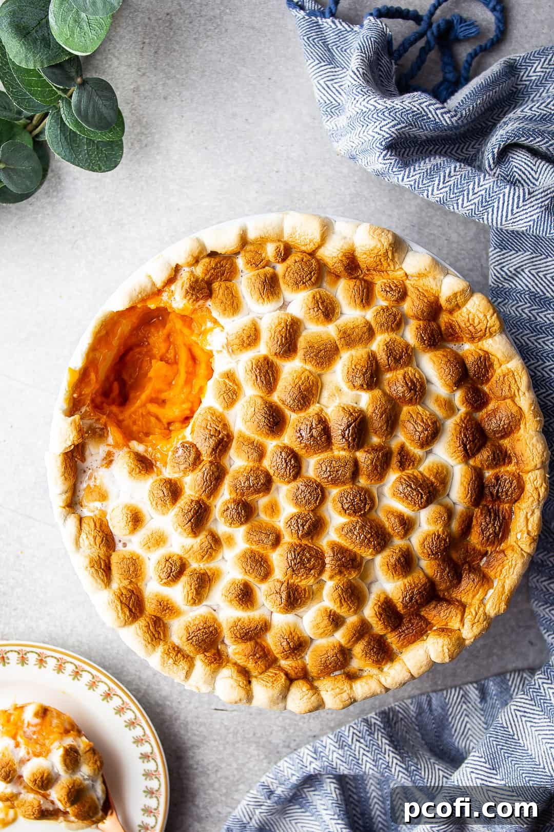 Overhead image of sweet potato casserole recipe, prepared and served in a round souffle dish, garnished with fresh herbs.