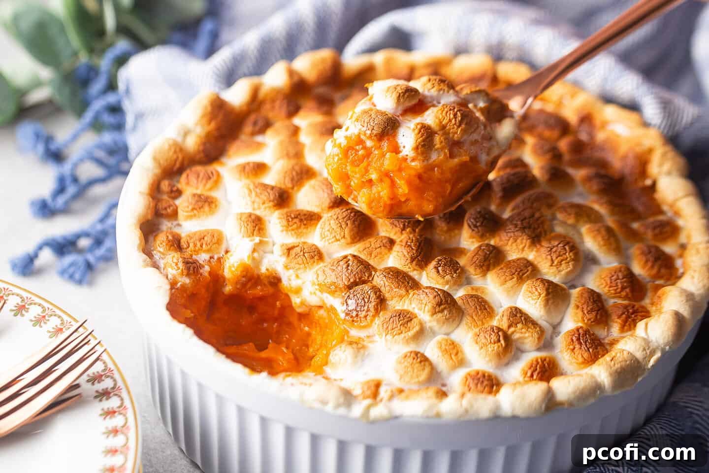 Dishing out a spoonful of sweet potato casserole with gooey, toasted marshmallows on top.