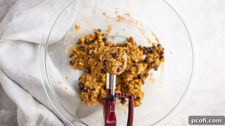 Scooping out protein cookie dough with a 1.5-tablespoon scoop.