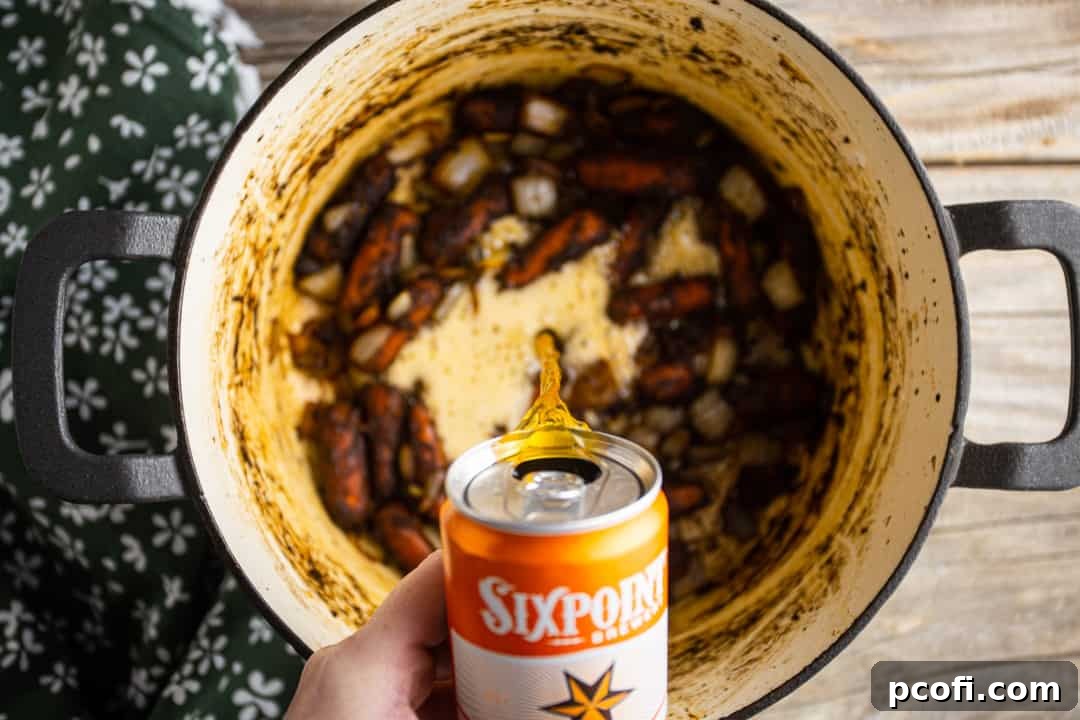 Deglazing the pot with beer, scraping up all the flavorful browned bits from the bottom.
