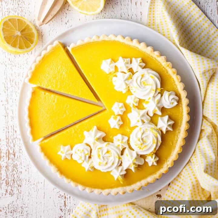 Overhead image of a beautifully sliced lemon tart adorned with delicate whipped cream rosettes, ready to be served.