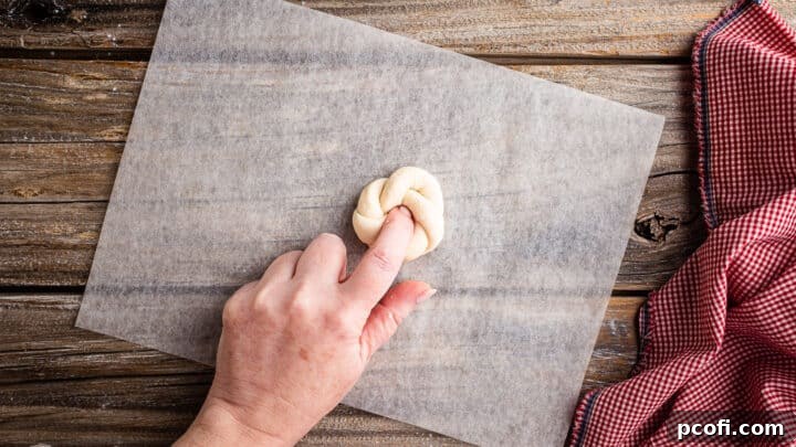 Pushing second end of garlic knot all the way through.