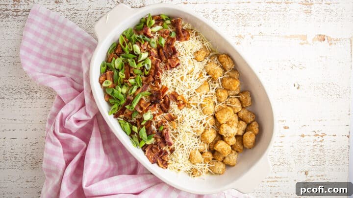 Layering potatoes with shredded cheese, bacon, and scallions.