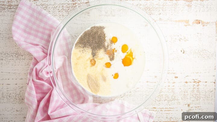 Eggs, milk, cream, and seasonings in a large mixing bowl.