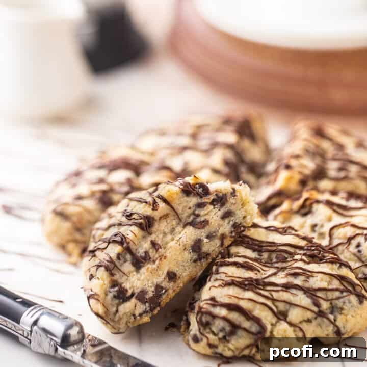 Delicious chocolate chip scones drizzled with melted dark chocolate, ready to be enjoyed with coffee.