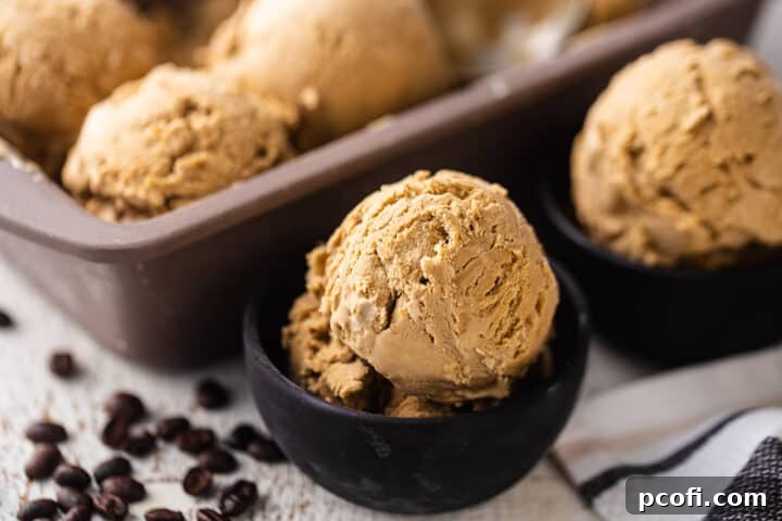 Two small bowls of scooped coffee ice cream sit beside a loaf pan filled with more scoops, showcasing the homemade treat in various serving presentations.