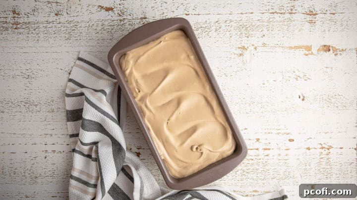 The creamy no-churn coffee ice cream base is shown in a loaf pan, ready to be placed in the freezer to solidify.