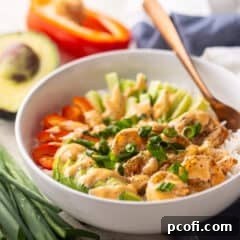 Grilled bang bang shrimp bowl with fresh veggies in the background.