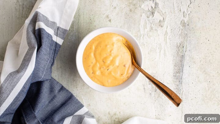 Homemade bang bang sauce in a small bowl with a copper spoon.