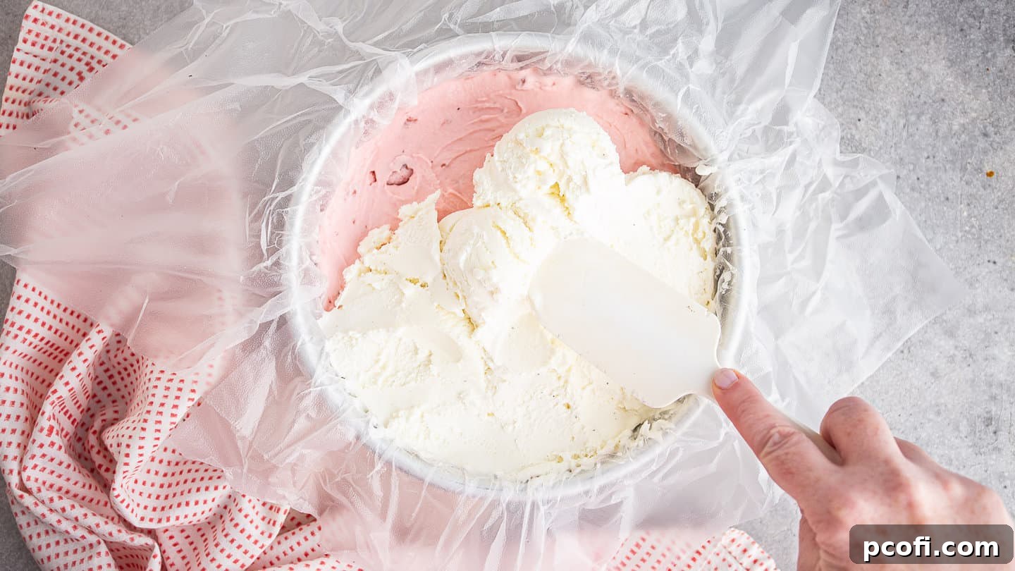 Layering vanilla ice cream over strawberry ice cream.