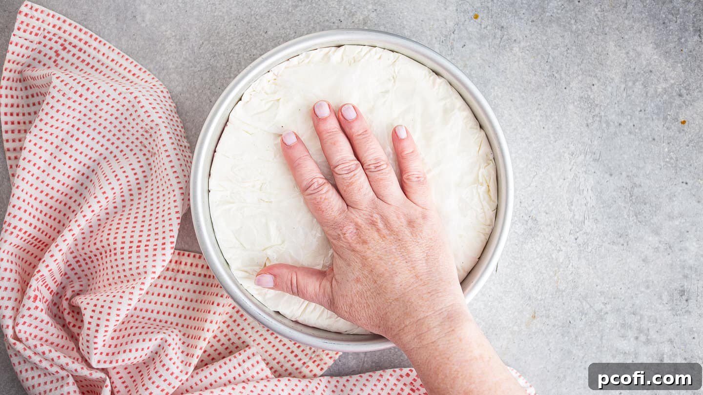 Wrapping molded ice cream up with plastic wrap.