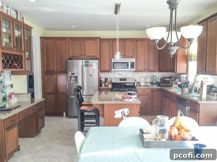 Before image of kitchen with medium-brown stained wood cabinets