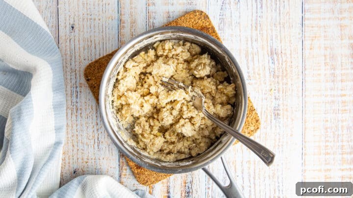 The mixed crumb topping for blueberry crumble, with a fork, in a small pot, showing its perfect crumbly texture.