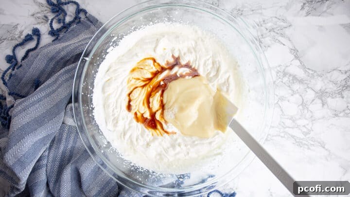 Adding sweetened condensed milk, vanilla extract, and salt to the whipped cream in a mixing bowl.