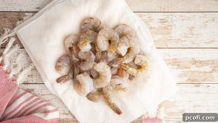Raw shrimp meticulously seasoned with salt and pepper, ready for breading.