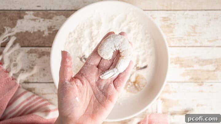 Uncooked shrimp, perfectly dusted with a thin layer of flour, ready for the next step.