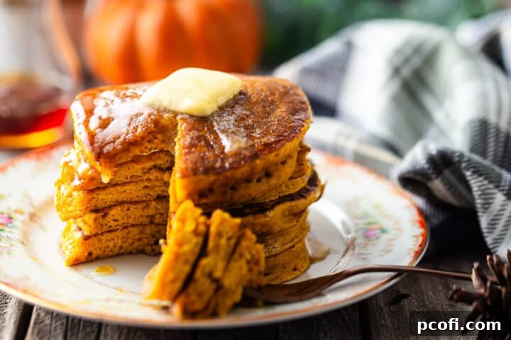Pumpkin spice pancakes with a bite taken out to display the fluffy texture.