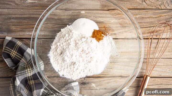 Dry ingredients for pumpkin pancakes, in a large glass mixing bowl.