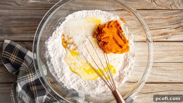 Adding liquid ingredients to pumpkin pancake batter.