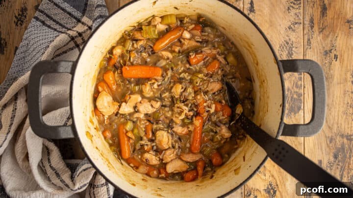 Simmering chicken and wild rice soup until the rice is cooked.