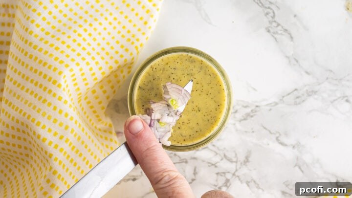 Adding finely minced shallot to the prepared lemon vinaigrette, enhancing flavor and texture.