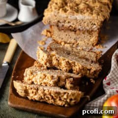 A beautiful loaf of apple bread on a wooden serving tray, ready to be enjoyed.