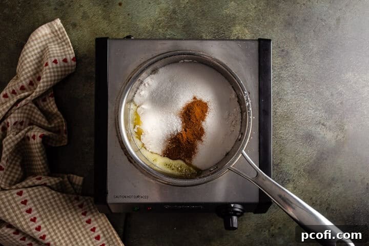 A small pot holding melted butter, flour, sugar, cinnamon, and salt—the core ingredients for the delightful cinnamon crumb topping.