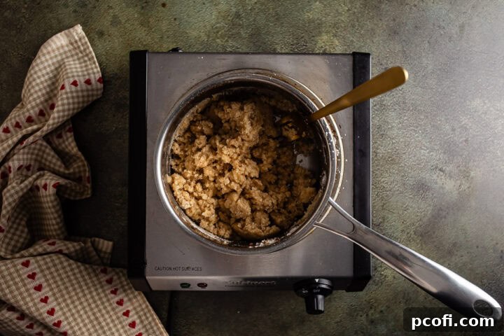 The cinnamon streusel topping, showcasing its crumbly texture, prepared in a small saucepan.