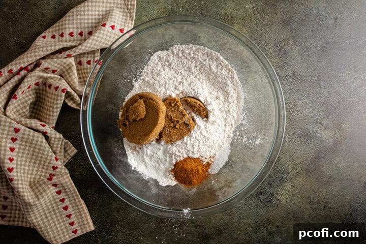 Dry ingredients for the apple bread batter, including flour, brown sugar, baking powder, cinnamon, and salt, mixed in a large glass bowl.