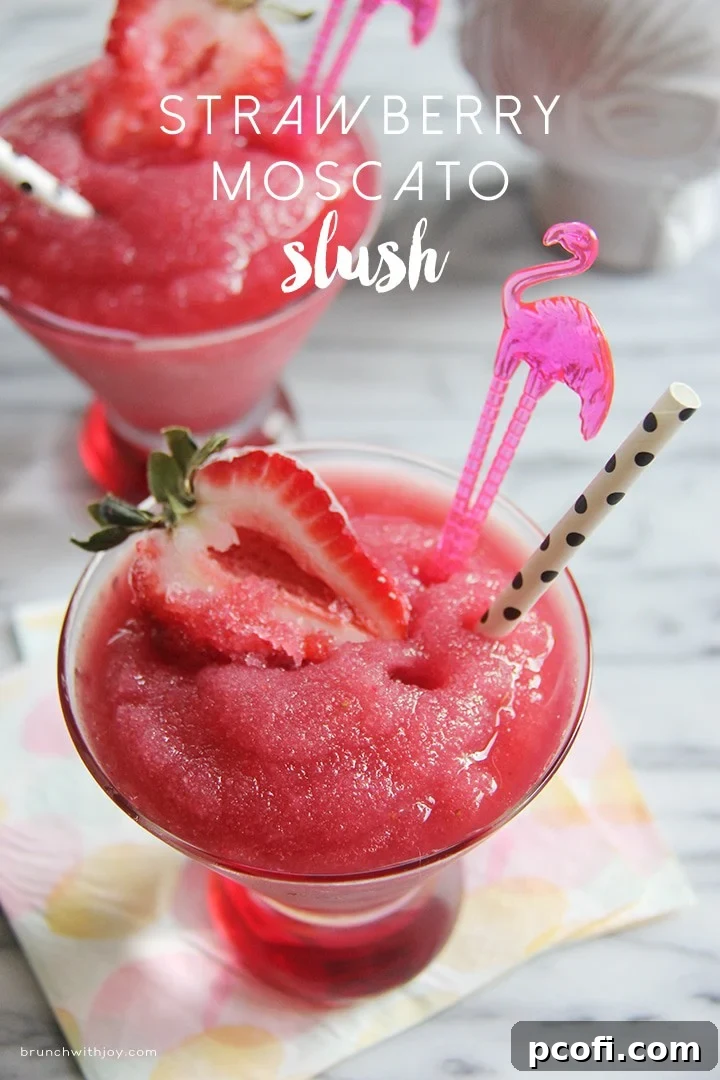 Close-up of a Strawberry Moscato Slush, garnished with fresh strawberries, ready for a summer party.