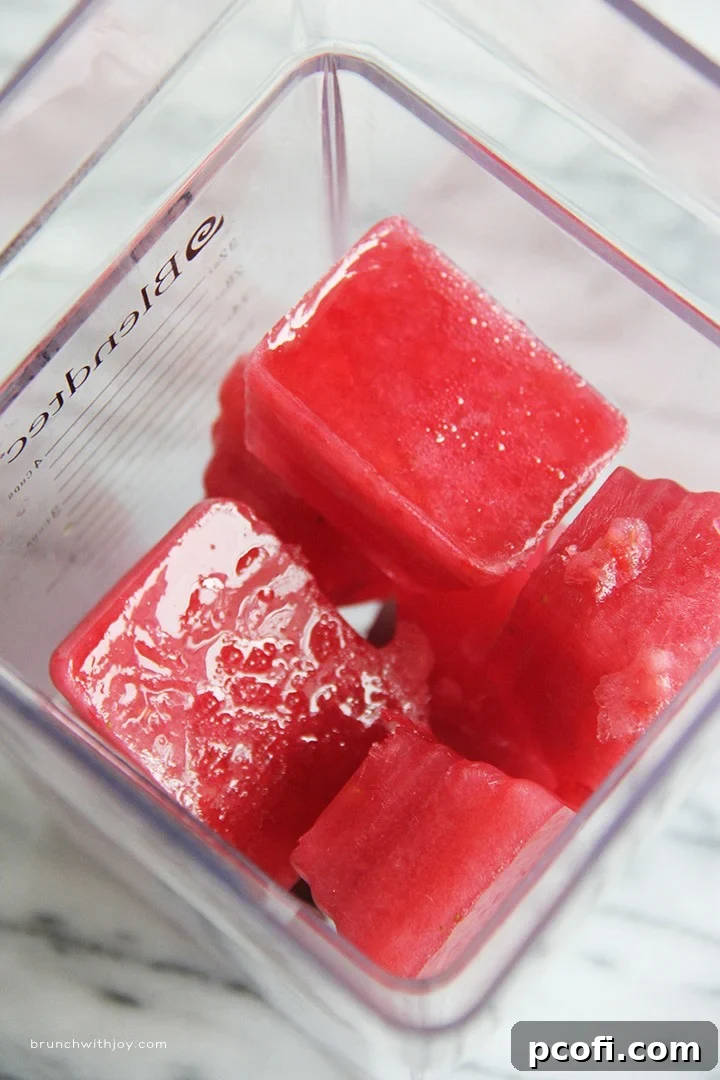 Close-up of a glass filled with Strawberry Moscato Slush, garnished with a whole strawberry.