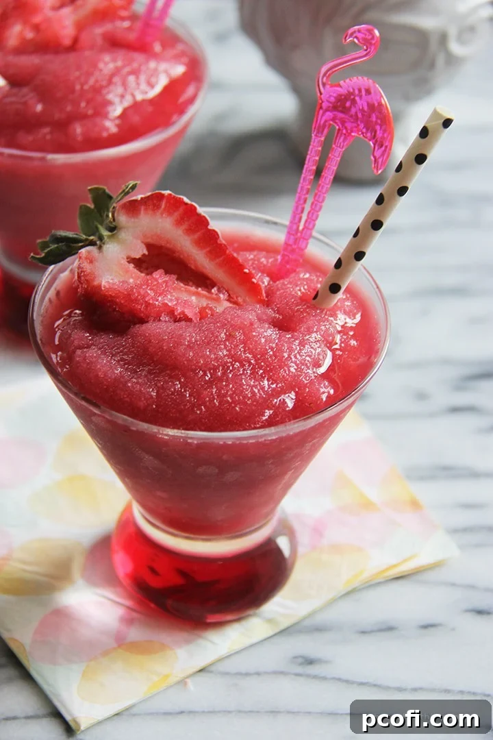 Two glasses of Strawberry Moscato Slush, showing the vibrant red color and icy texture, ready to be served.