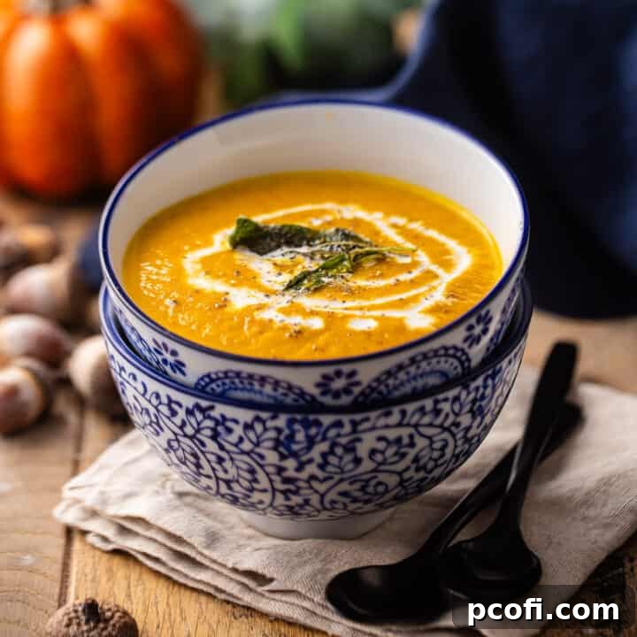 A comforting bowl of pumpkin soup garnished with fresh sage and a swirl of cream, ready to be enjoyed.
