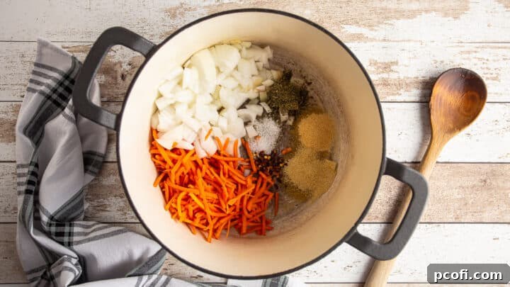 Onion, carrots, and seasonings for making tomato sauce, in a large pot.