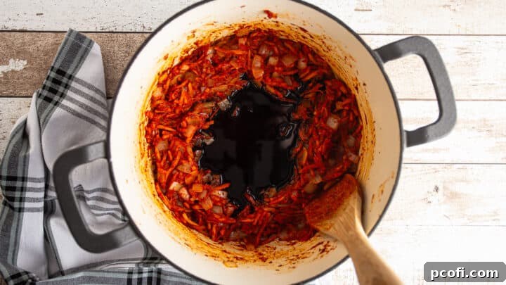 Adding balsamic vinegar to deglaze the pan.