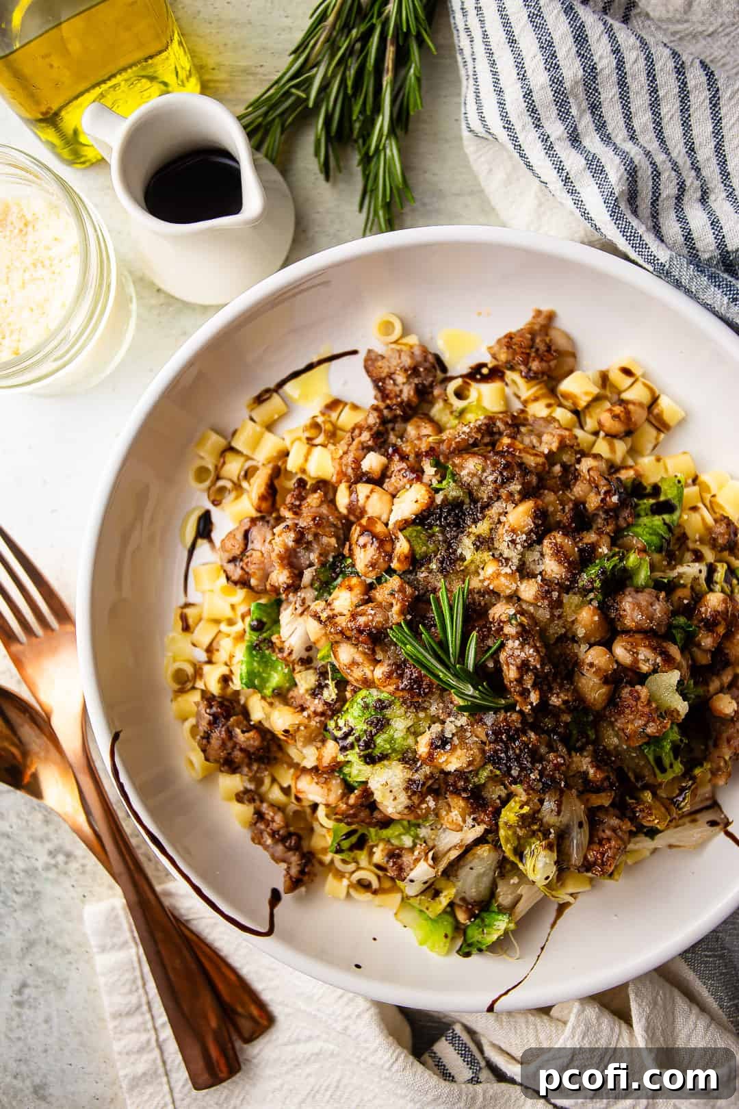 Escarole and beans served over ditalini pasta with crumbled Italian sausage, garnished with balsamic glaze and Parmesan cheese.