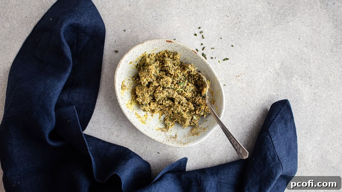 The herbed compound butter after being perfectly mixed to form a thick, vibrant green paste, showcasing its smooth texture.