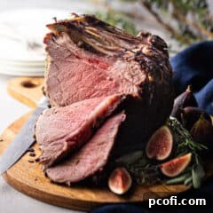 Standing rib roast, sliced and presented on a wooden carving board.