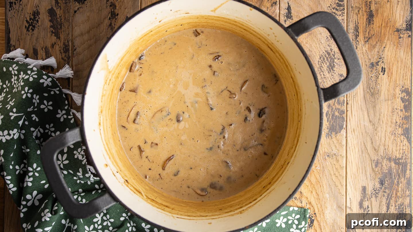 Creamy sauce for green bean casserole, in a large enameled cast iron Dutch oven.