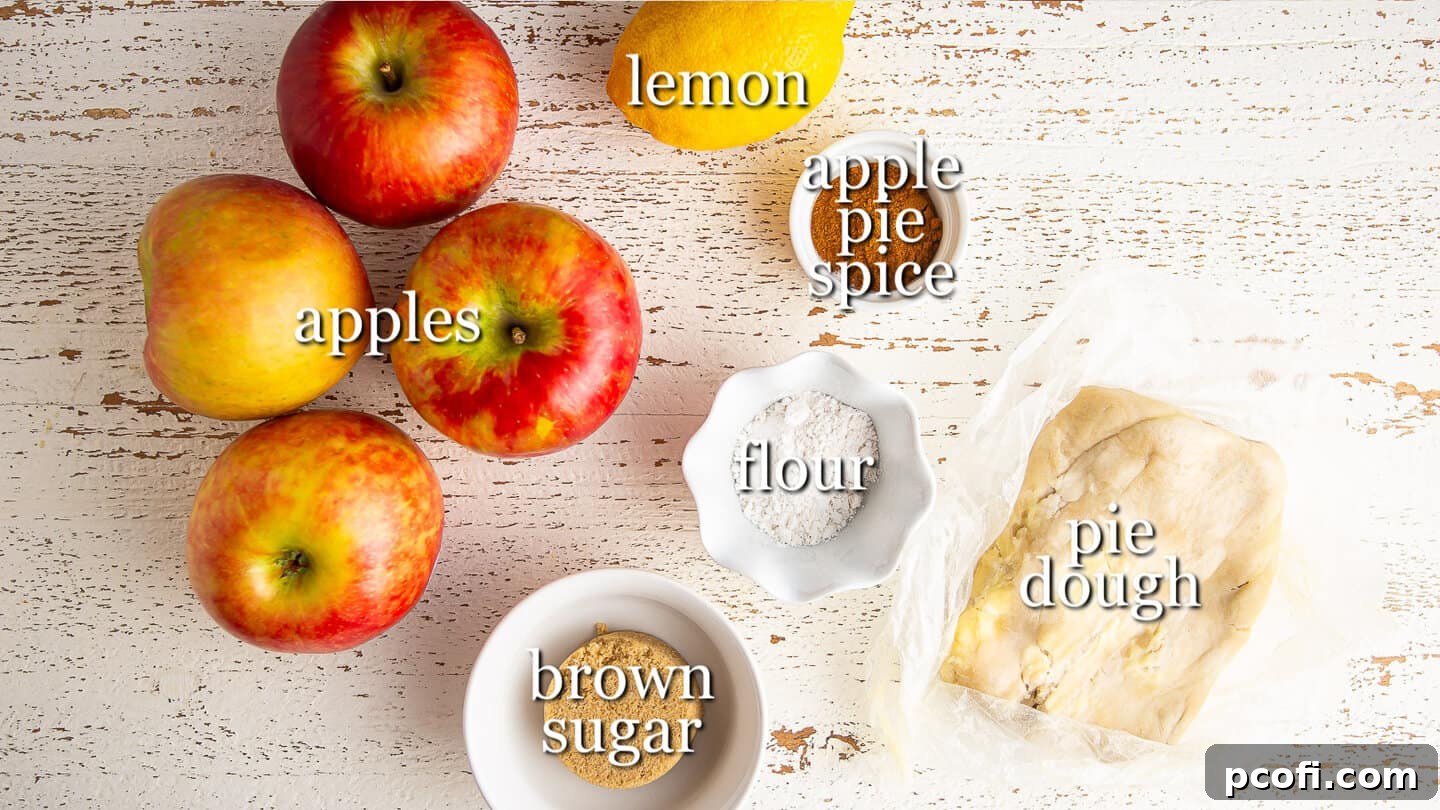 Ingredients for making an apple galette, clearly labeled and neatly arranged in a rustic setting.