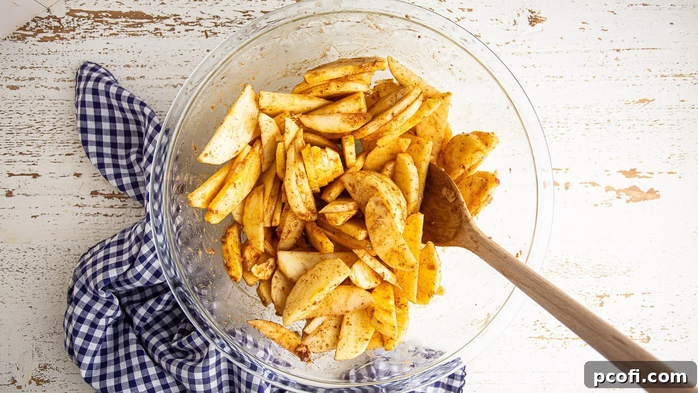 Apple galette filling, perfectly mixed and glistening in a large bowl, ready for assembly.