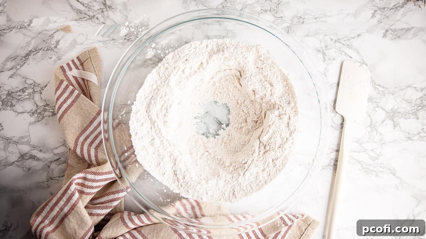 A well meticulously formed in the center of the dry ingredients, ready to receive liquid components for the muffin batter.