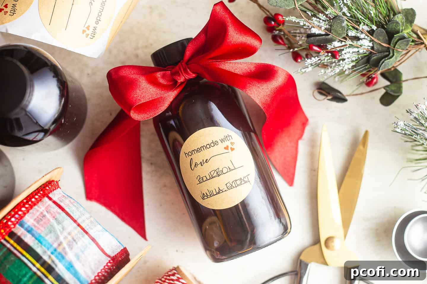 Three bottles of homemade vanilla extract, beautifully prepared with gift tags and red ribbons, ready to be presented as thoughtful presents.