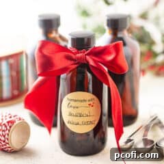 Homemade vanilla extract in amber glass bottles with a red satin ribbon, ready for gifting.