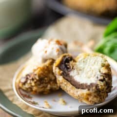 Stuffed mushrooms cut in half to display the creamy garlic and herb cheese inside.