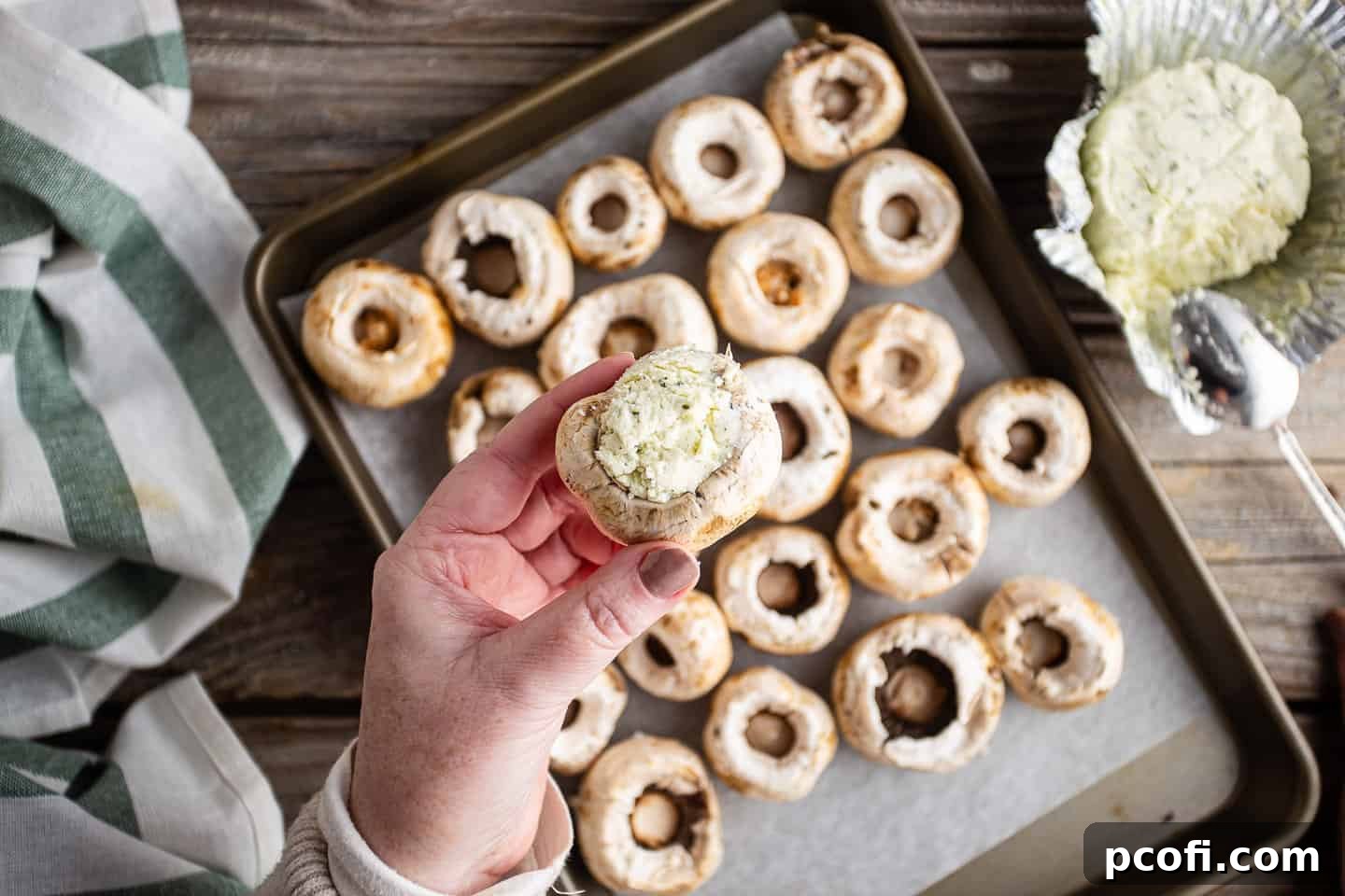 Stuffing mushroom cap with soft garlic and herb cheese.
