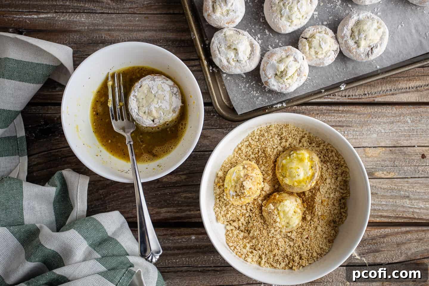Coating stuffed mushrooms with egg and breadcrumbs.