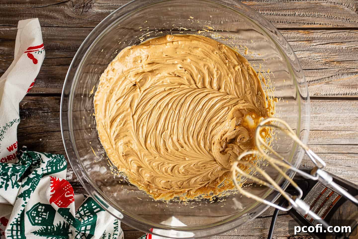 Whipping butter and peanut butter together with an electric hand mixer.