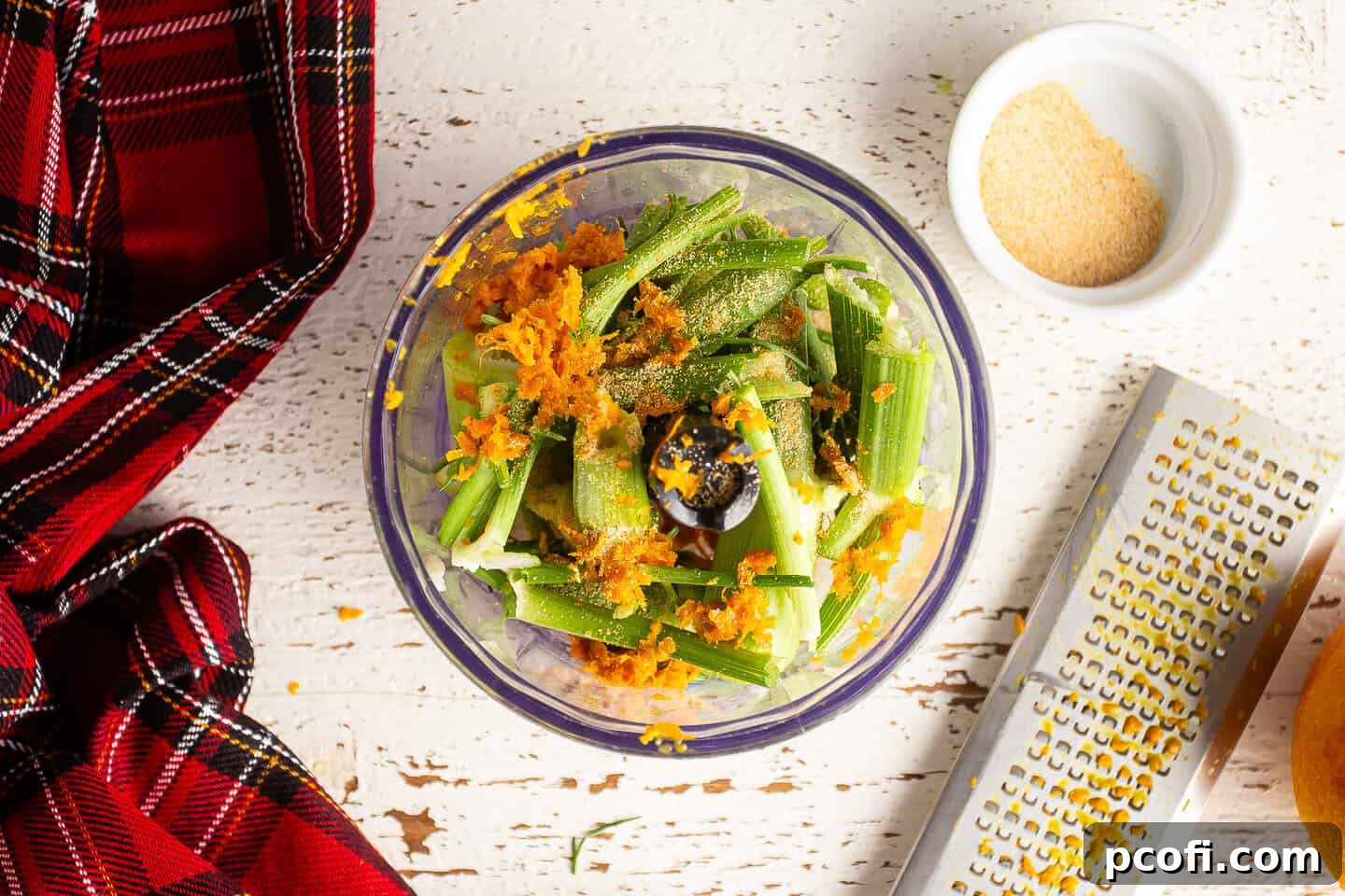 Fennel tops, orange zest, and garlic, in the bowl of a mini-chopper.