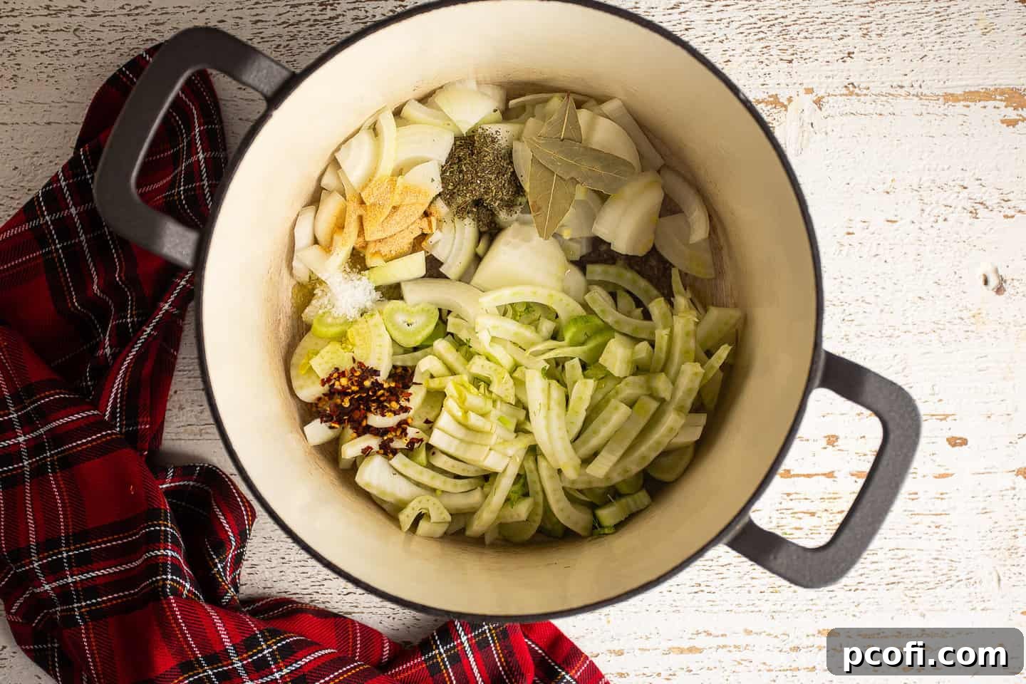 Fennel, onion, and seasonings in a large enameled cast-iron Dutch oven.